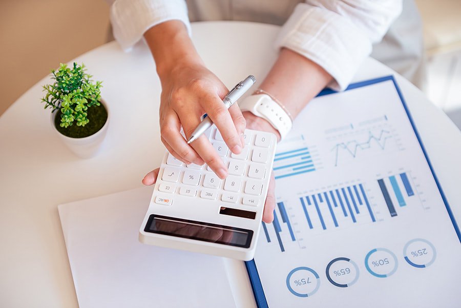 Cost of Living in Portugal Compared to the US 1 Hand with calculator calculating the cost of living in Portugal compared to the US