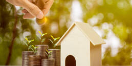 Golden Visa Program Investments Soar by 27.5% in H1 2023 41 Hand placing coins into a house as a symbol of property investment