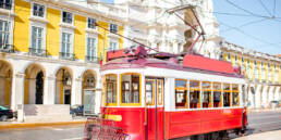 Property Investment Guide: Cheapest and Most Expensive Locations in Portugal 2023 34 A vintage tram in front of a picturesque Lisbon backdrop, a top destination in the Property Investment Guide.