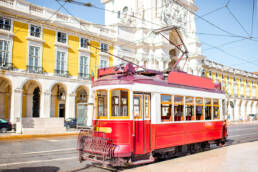 Property Investment Guide: Cheapest and Most Expensive Locations in Portugal 2023 6 A vintage tram in front of a picturesque Lisbon backdrop, a top destination in the Property Investment Guide.