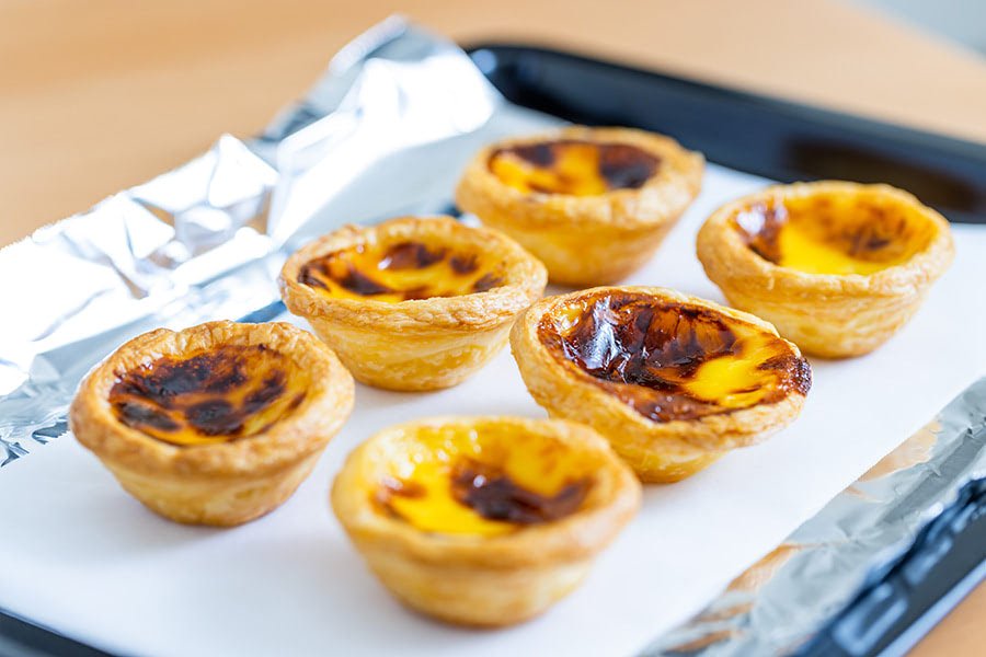 What makes Portuguese cuisine unique? 2 Close up view of Pastéis de Nata, a popular dessert in Portuguese cuisine