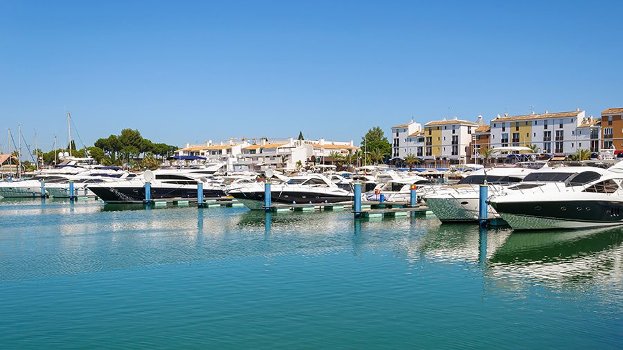 Yachts docked in a scenic harbor in Portugal under the Mediterranean sun, representing the country's warm climate